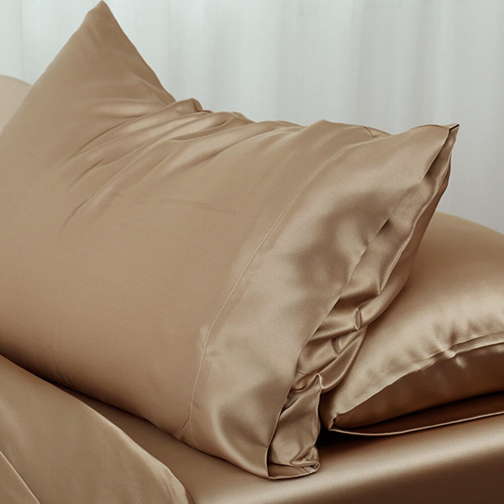 A Pair Of Gold Colored Silk Pillowcases Kept On A Bed